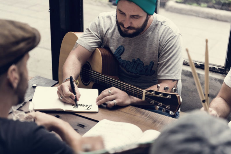 Musical-collaborators-writing-_Tunedly_-in-a-journal-e1497837568892